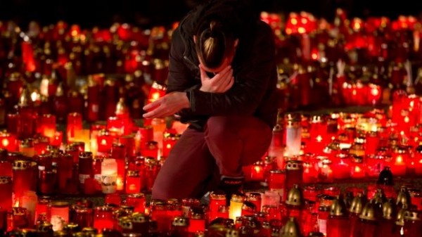 A young man mourning the dead in front of the Colectiv club