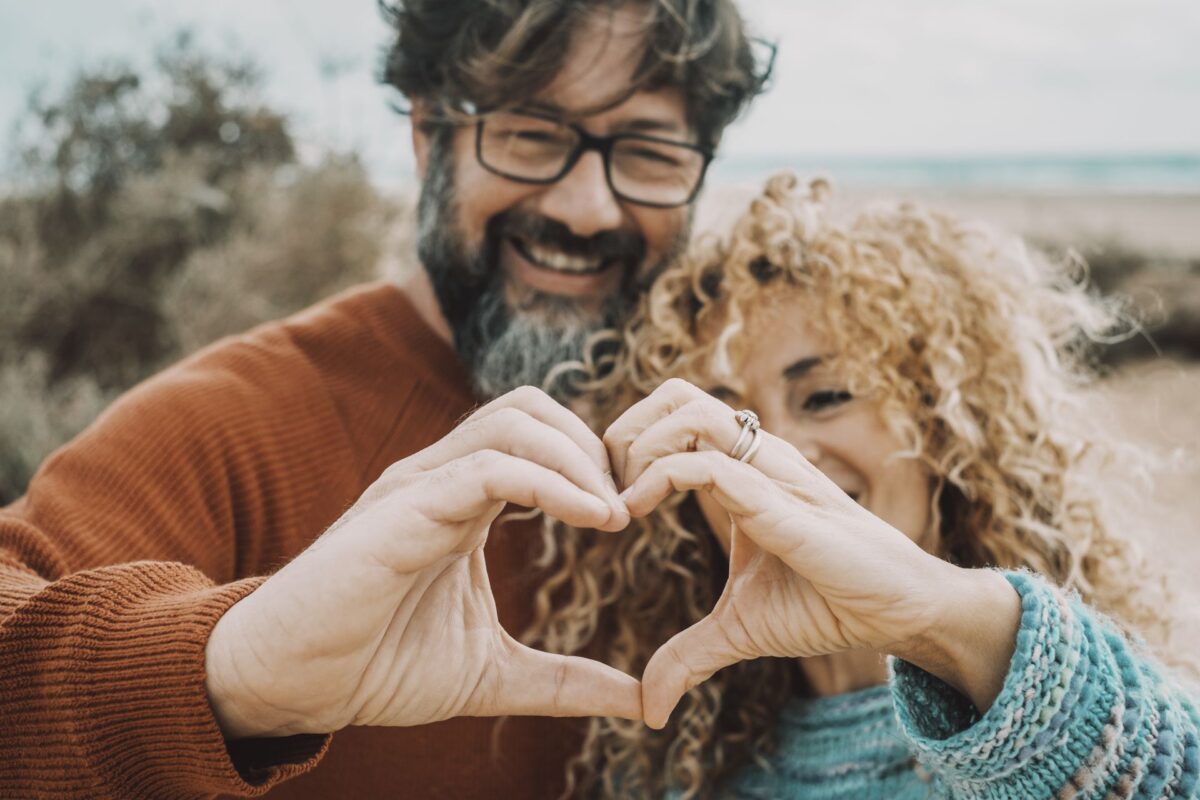 couple making a heart shape with their hands