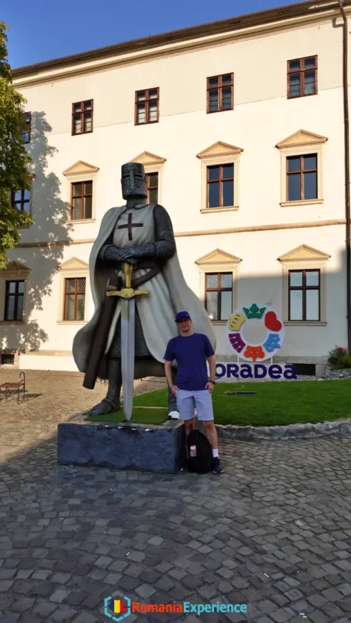 posing by a knight statue in Oradea Citadel